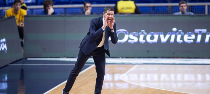 Entrenador animando a su equipo durante un partido de baloncesto en la cancha.