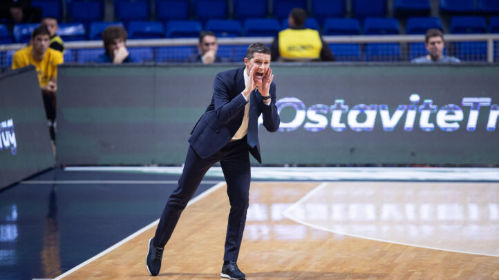 Entrenador animando a su equipo durante un partido de baloncesto en la cancha.