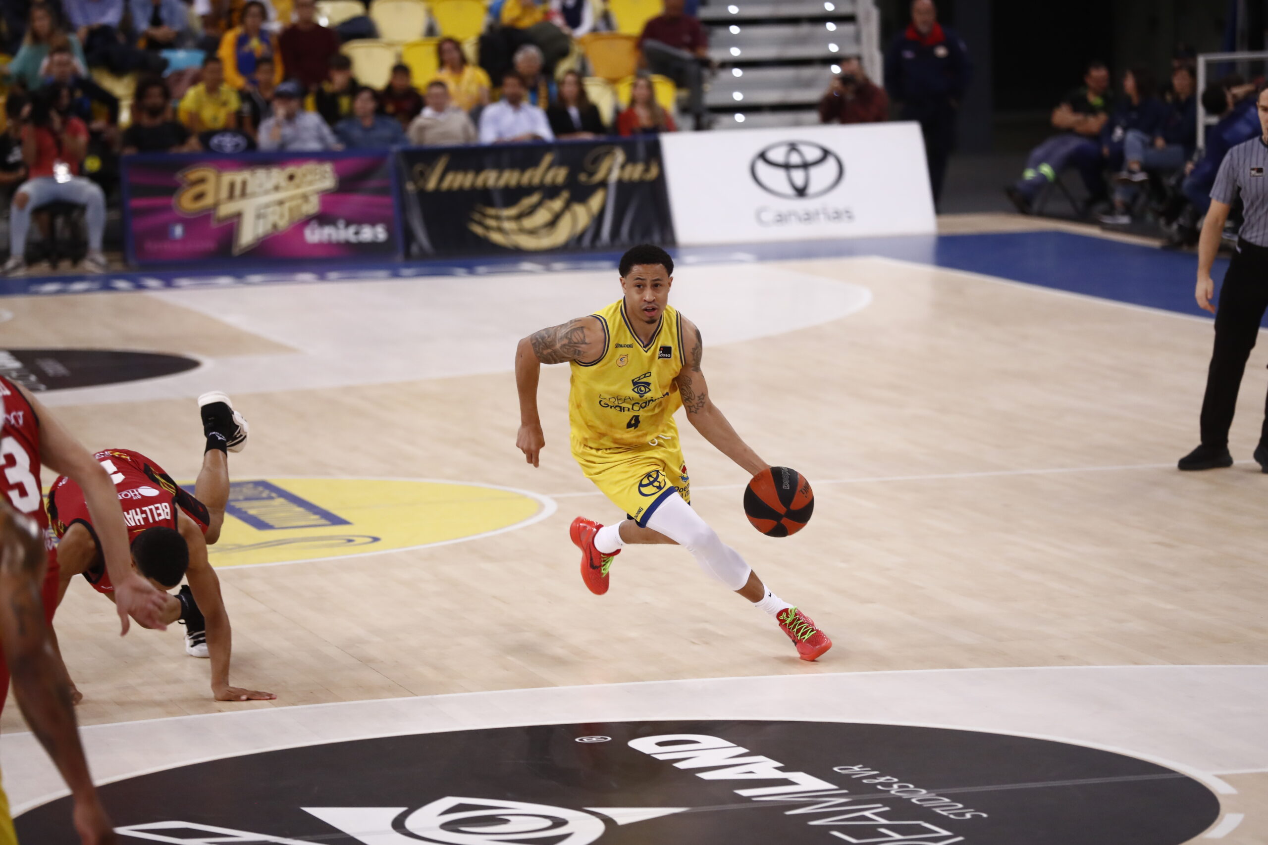 Jugador del Dreamland Gran Canaria avanza con el balón en un partido de baloncesto.