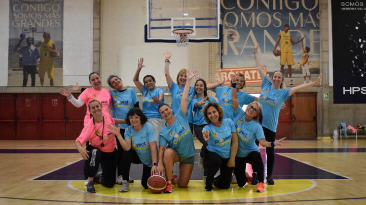 testimonios del Proyecto Carmen","Grupo de mujeres en pista de baloncesto, sonriendo y posando con camisetas del Proyecto Carmen.