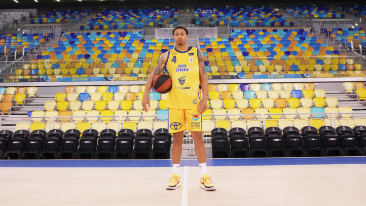 Jugador del Dreamland Gran Canaria con balón, vistiendo camiseta retro en la cancha.