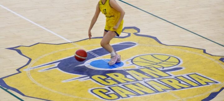 Jugadora de baloncesto driblando un balón sobre la cancha del Club Baloncesto Gran Canaria.
