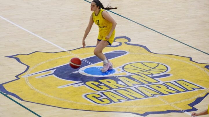 Jugadora de baloncesto driblando un balón sobre la cancha del Club Baloncesto Gran Canaria.