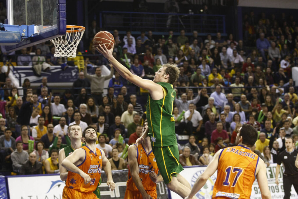 Brad Newley en acción, lanzando a canasta durante un partido de baloncesto.