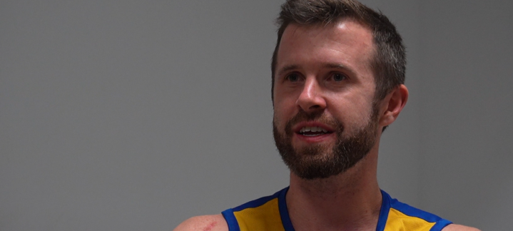 Jugador de baloncesto John Shurna, sonriente durante una entrevista en el club.