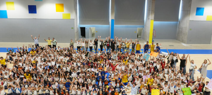 Un gran grupo de escolares sonrientes celebra en el gimnasio del club.