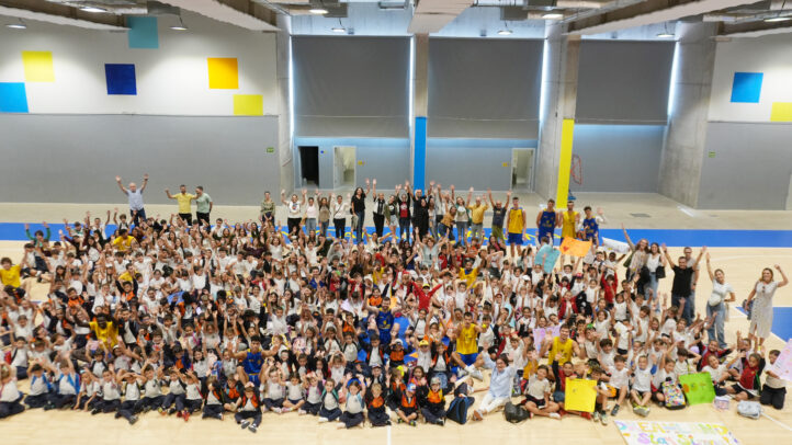 Un gran grupo de escolares sonrientes celebra en el gimnasio del club.
