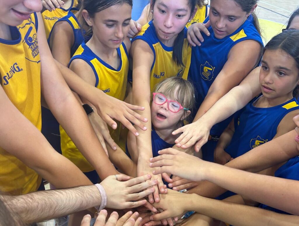 Jugadoras del equipo se unen en un gesto de apoyo y camaradería antes de un entrenamiento.