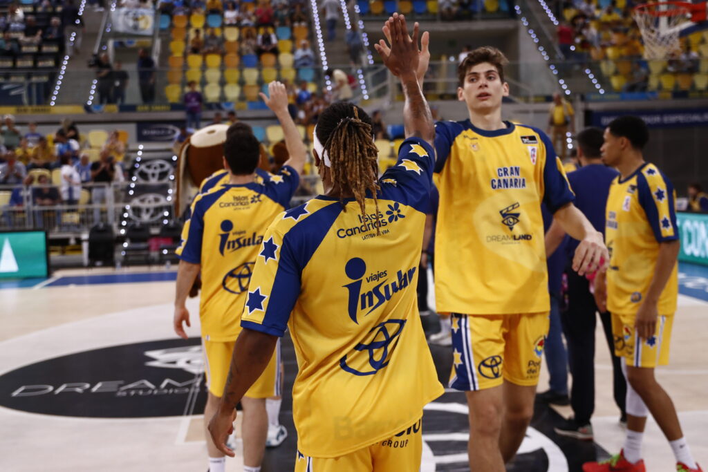 en preventa","Jugadores del Gran Canaria saludan durante un partido, vistiendo equipaciones retro.