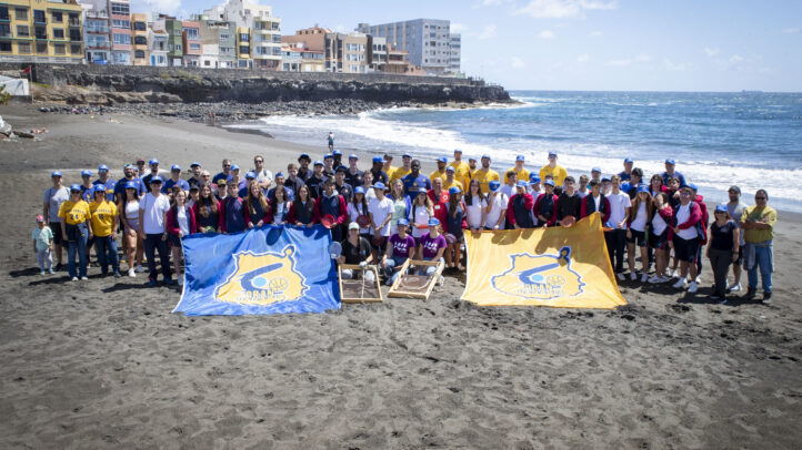 con su iniciativa 'Compromiso Granca', limpia la playa de La Garita","Grupo grande de personas en la playa de La Garita, con banderas del CB Gran Canaria.