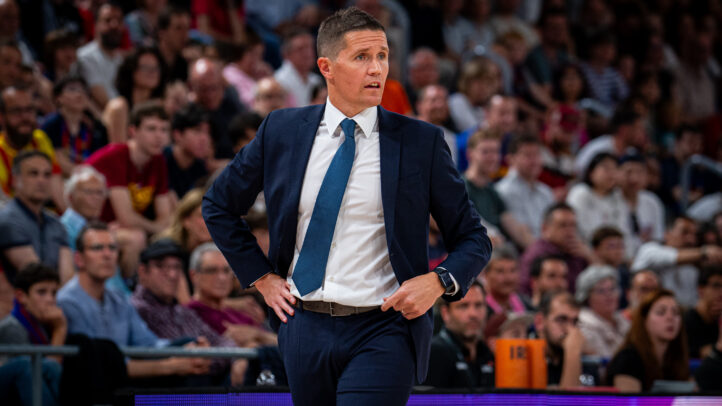 Entrenador Jaka Lakovic en un partido con la afición de fondo, mostrando atención y concentración.