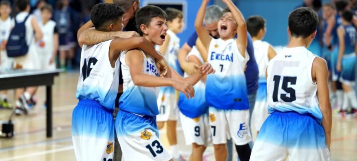 Jugadores de minibasket celebrando juntos tras un partido en el gimnasio.