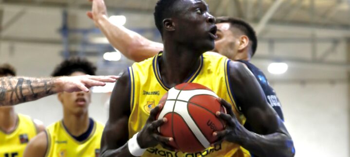Pívot Massamba Diop sostiene un balón de baloncesto en un partido.