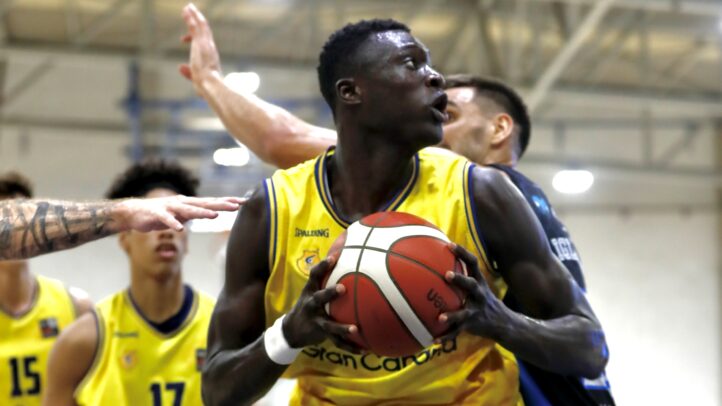Pívot Massamba Diop sostiene un balón de baloncesto en un partido.