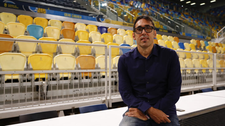 Willy Villar sentado en una cancha de baloncesto con gradas vacías de fondo.