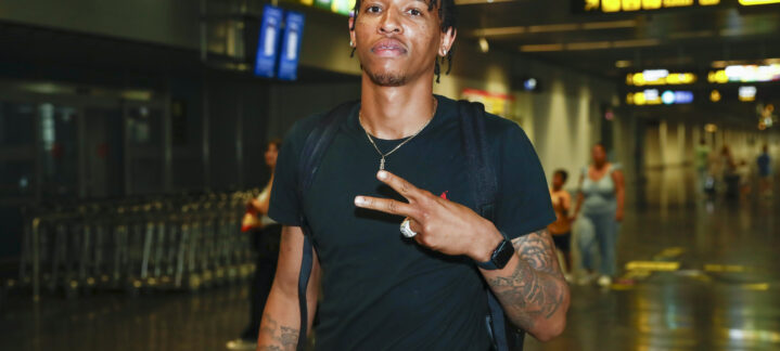mental y emocionalmente""","Joe Thomasson posando en un aeropuerto, mostrando un gesto de paz y confianza.