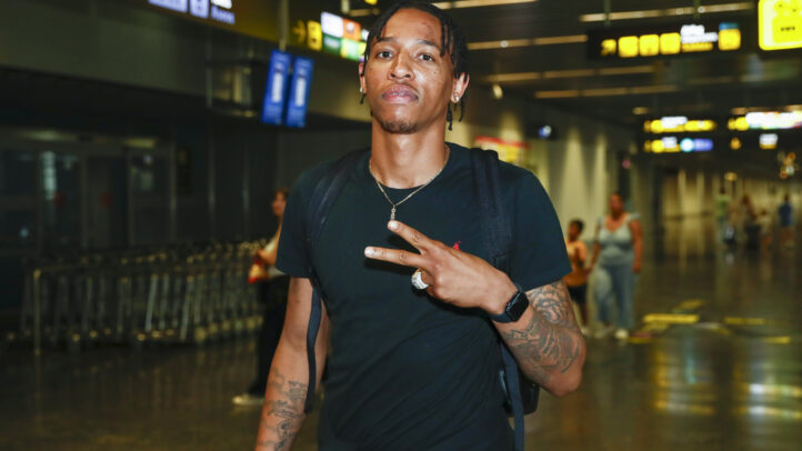 mental y emocionalmente""","Joe Thomasson posando en un aeropuerto, mostrando un gesto de paz y confianza.