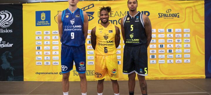 Tres jugadores del Dreamland Gran Canaria posan con diferentes uniformes, frente a un fondo colorido.