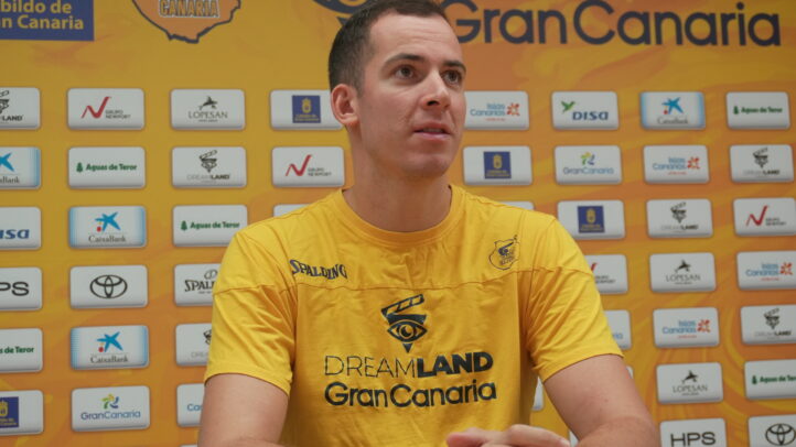 Jugador del Club Baloncesto Gran Canaria en rueda de prensa, con fondo de patrocinadores.