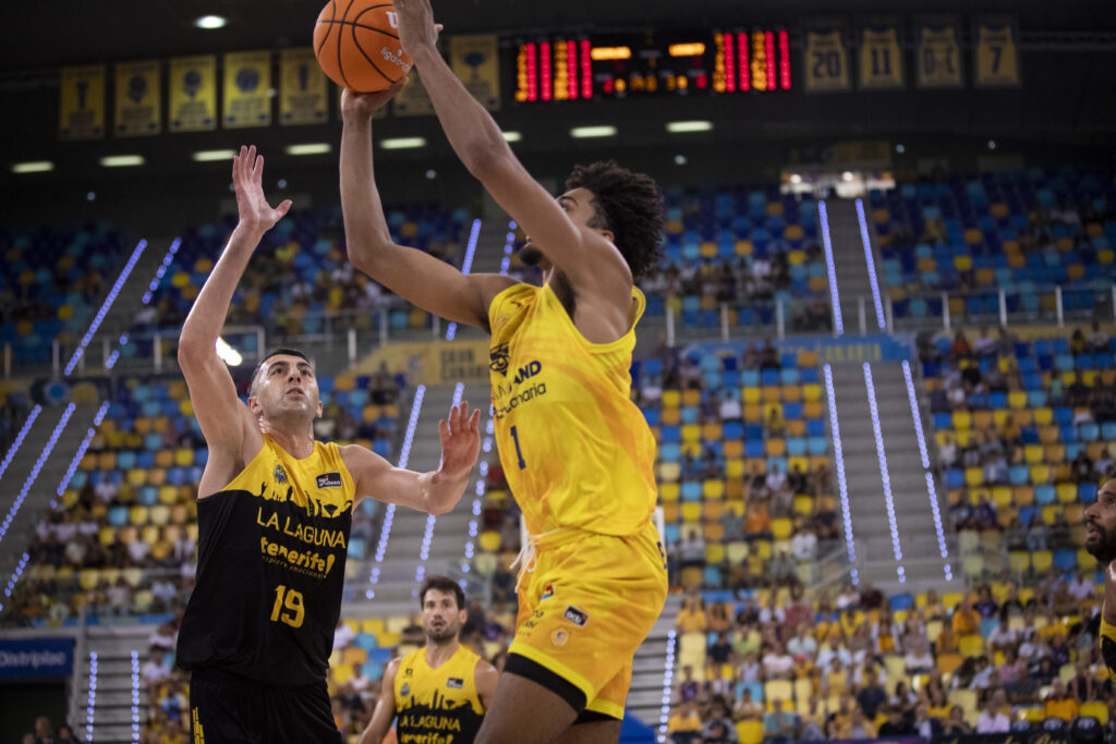 Jugador del Dreamland Gran Canaria lanza a canasta mientras es defendido por un oponente.