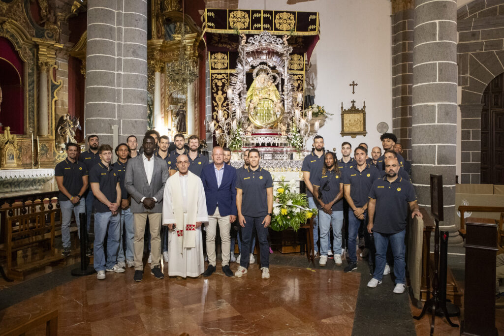 Equipo del Gran Canaria posando con ofrenda floral frente a la Virgen del Pino.
