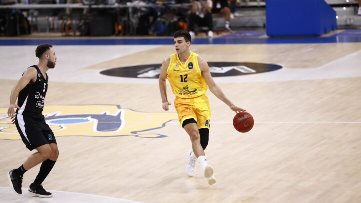 Jugador con balón en la cancha durante un partido de baloncesto en el Gran Canaria Arena.