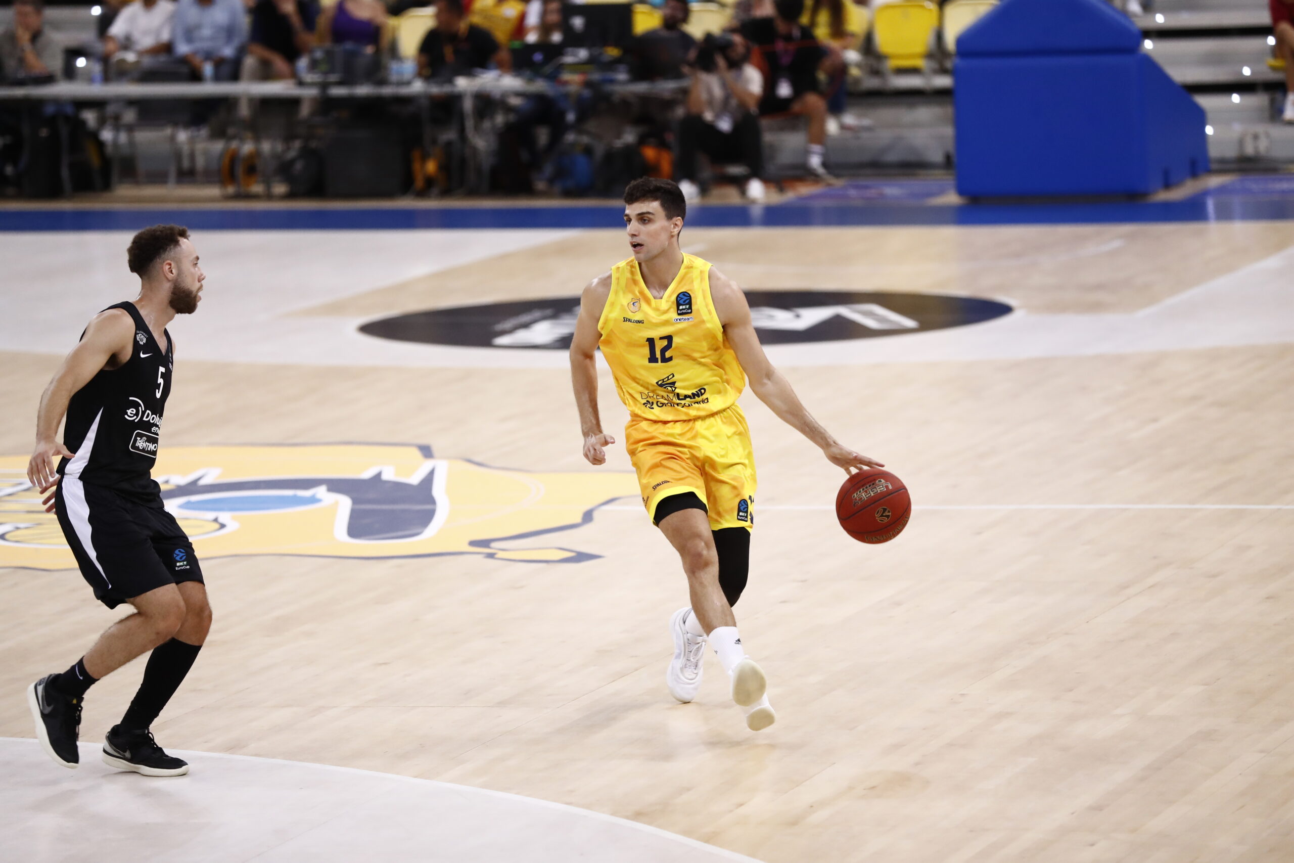 Jugador con balón en la cancha durante un partido de baloncesto en el Gran Canaria Arena.