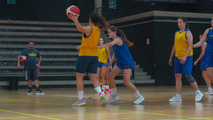 Jugadoras de baloncesto entrenando en el gimnasio, lanzando el balón y en acción.