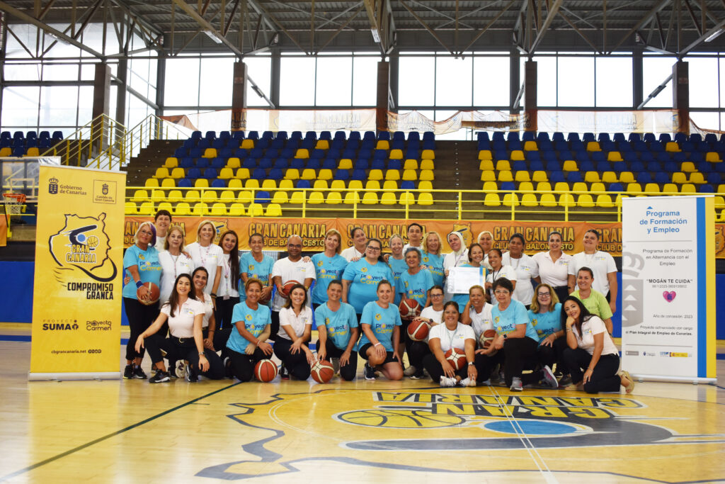 Grupo de personas sonrientes en una cancha de baloncesto, en evento comunitario.