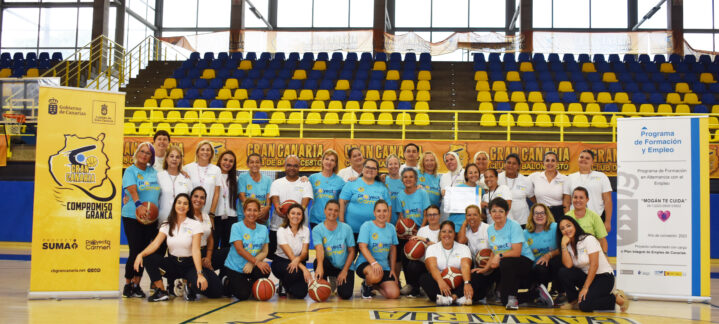 Grupo de personas sonrientes en una cancha de baloncesto, en evento comunitario.