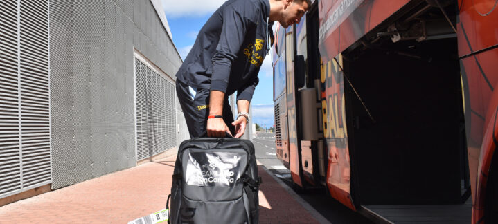 Jugador con mochila preparando el equipaje para abordar el autobús del equipo.
