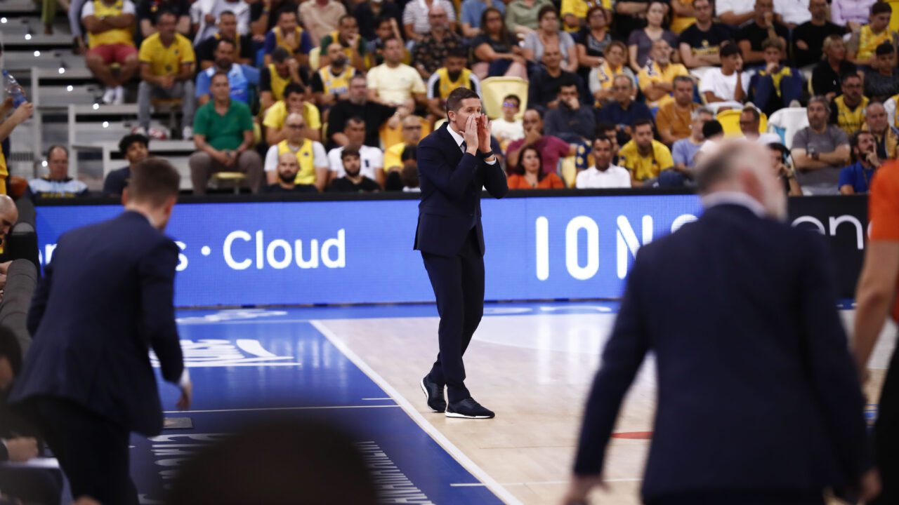 Entrenador del CB Gran Canaria da instrucciones en un partido con afición de fondo.