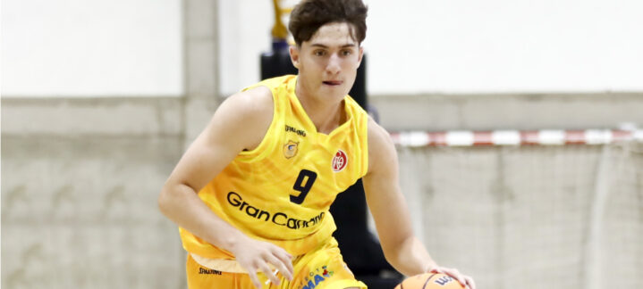 Jugando al baloncesto, un jugador del Gran Canaria avanza con el balón en la mano.