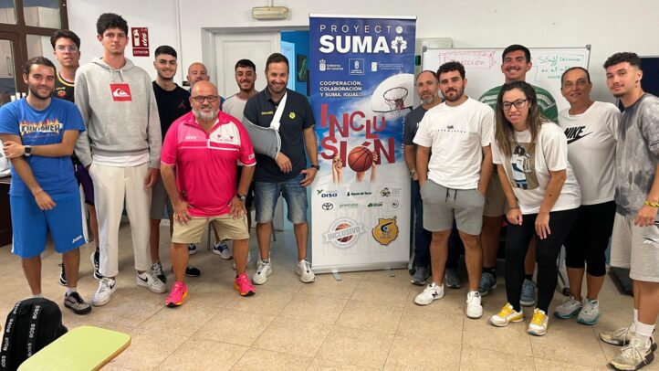 Grupo de personas posando frente a un cartel del Proyecto Suma sobre inclusión.