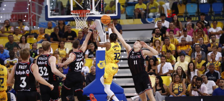 Jugador del Dreamland Gran Canaria lanza a canasta mientras es defendido en un partido.