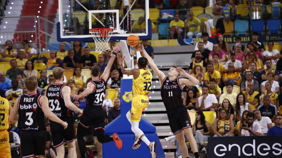 Jugador del Dreamland Gran Canaria lanza a canasta mientras es defendido en un partido.