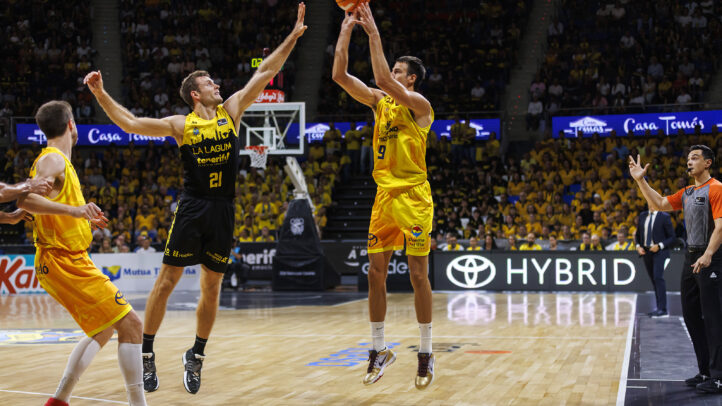 en diez claves",Jugador lanza el balón mientras un defensor salta cerca en un partido de baloncesto.