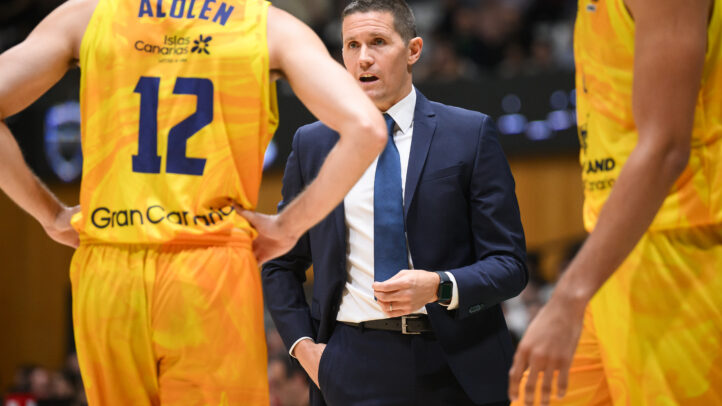 Entrenador Jaka Lakovic charlando con jugadores del equipo durante un partido.