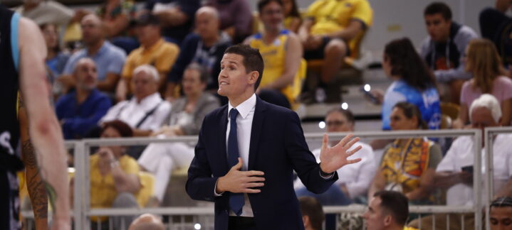 Entrenador en acción durante un partido, gesticulando y hablando con intensidad.