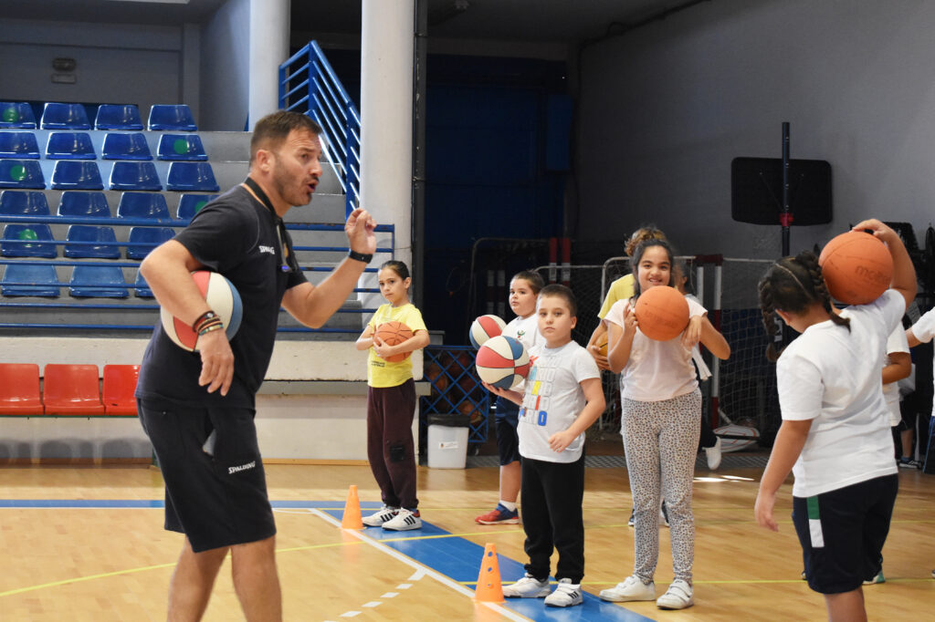 Entrenador dirige a niños en una sesión de baloncesto del Proyecto Suma en Telde.