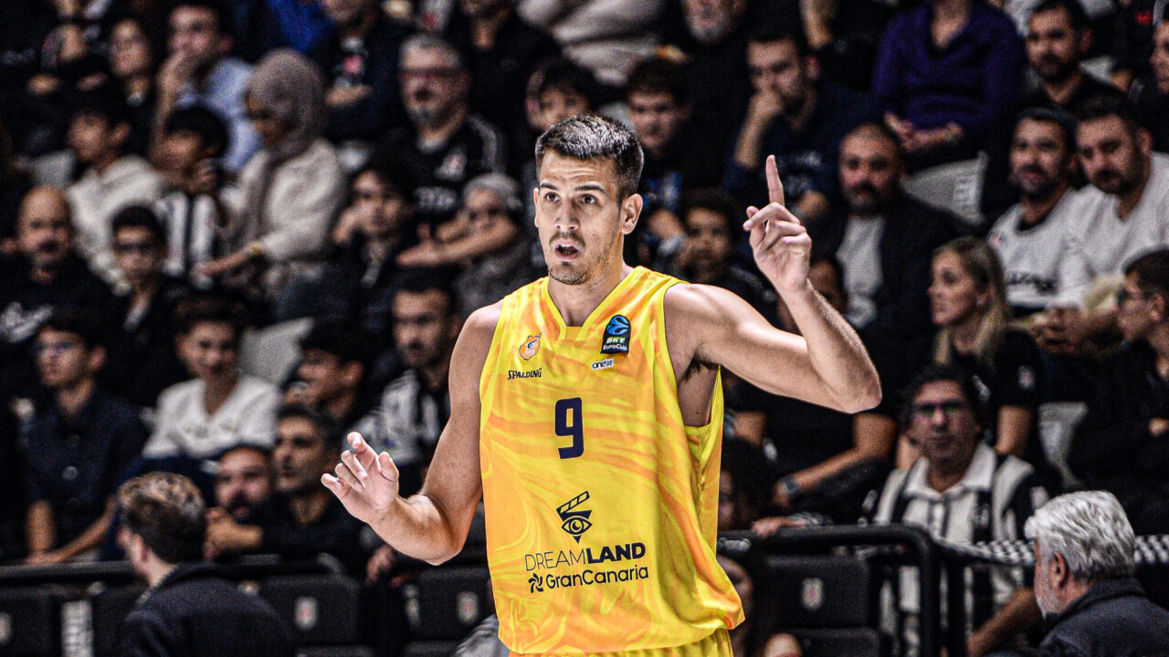 Jugador del Club Baloncesto Gran Canaria señalando, con aficionados al fondo.