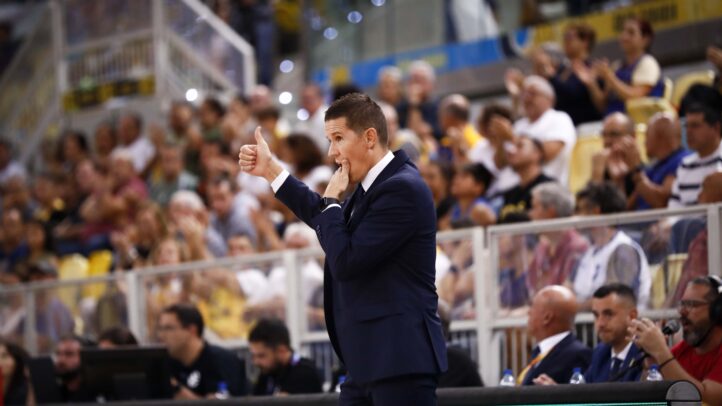 Entrenador gesticulando con un pulgar hacia arriba mientras dirige desde la línea de banda.