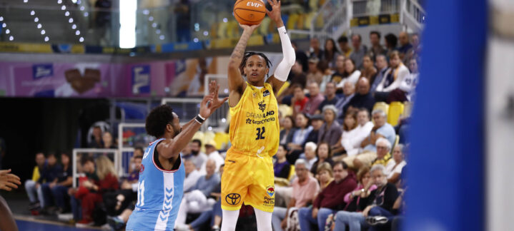 Jugador del Dreamland Gran Canaria lanza a canasta mientras es defendido en un partido.