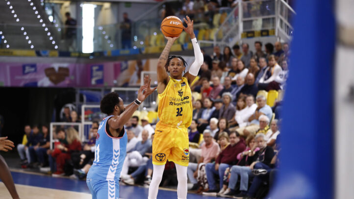 Jugador del Dreamland Gran Canaria lanza a canasta mientras es defendido en un partido.