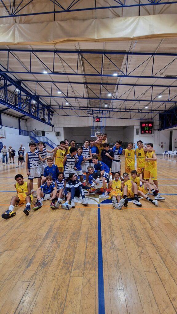 Jugadores de baloncesto preinfantil posan juntos en una cancha tras un evento en Tenerife.