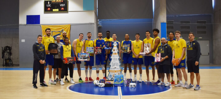 Jugadores del Club Baloncesto Gran Canaria posan con regalos para el Árbol de los Sueños.