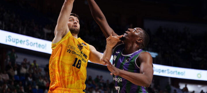 Jugador del Gran Canaria lanza a canasta bajo la defensa de un oponente en el Carpena.