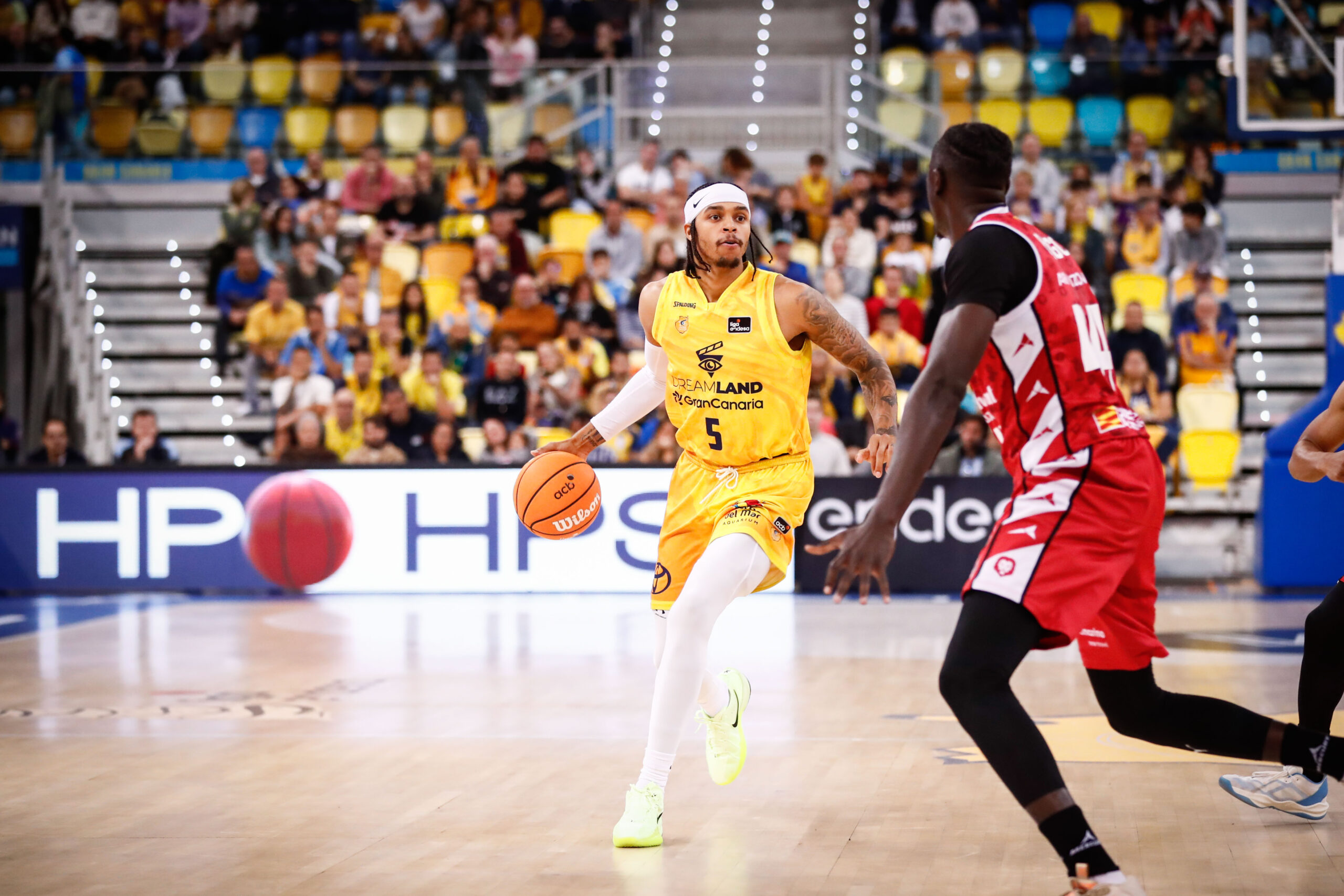 Jugador del Dreamland Gran Canaria driblando el balón en un partido de baloncesto.