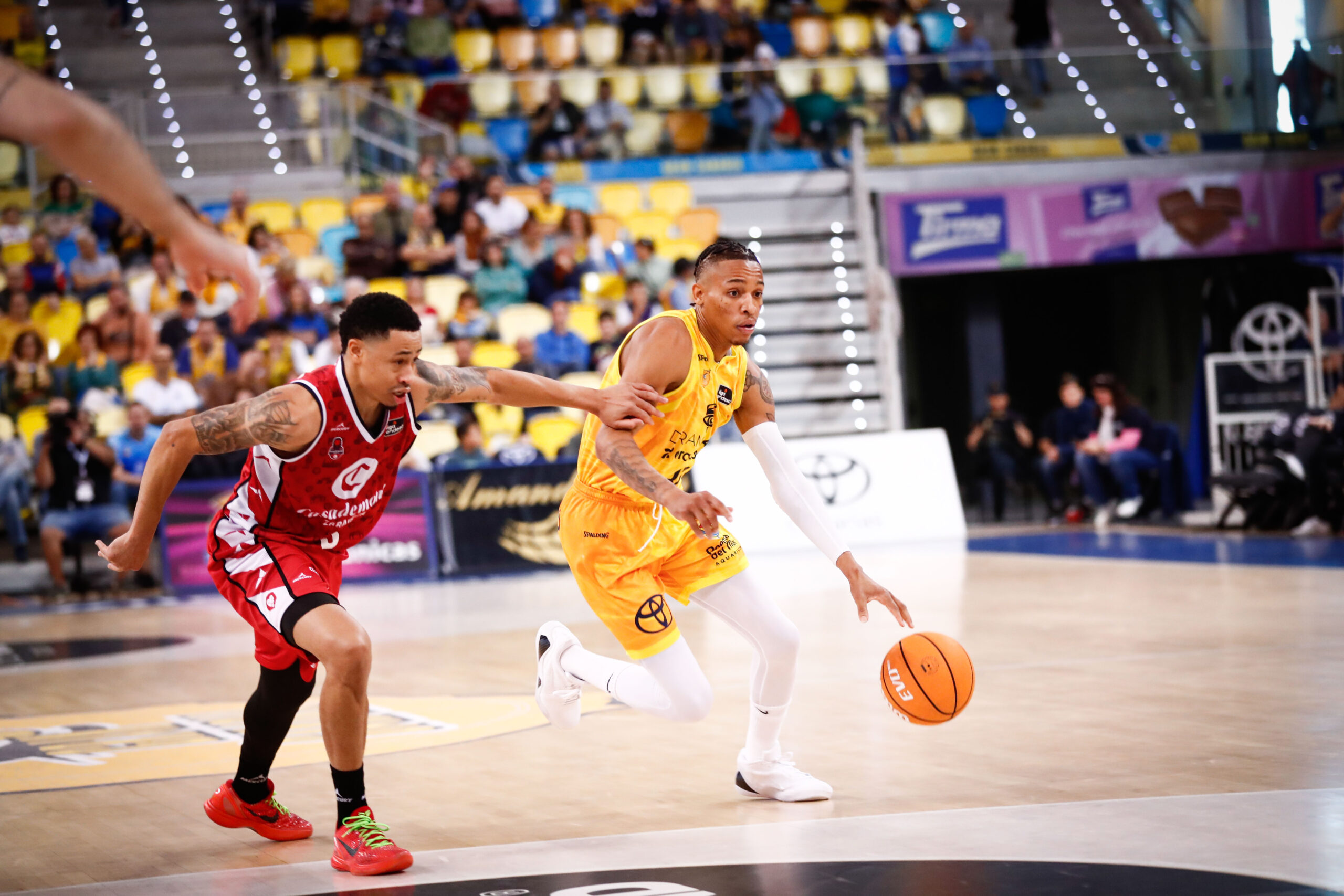 Jugadores de baloncesto compiten en plena acción en un partido.
