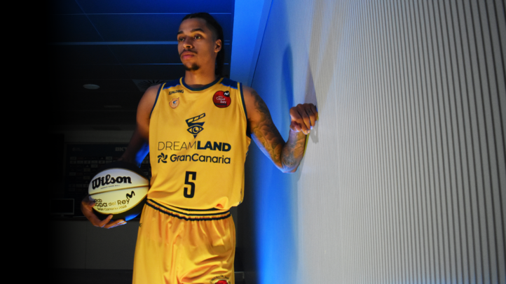 Jugador del Dreamland Gran Canaria con camiseta amarilla y balón de baloncesto.
